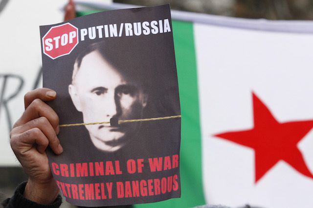 A protester holds a sign condemning Russian President Vladimir Putin at a demonstration last week in Berlin.